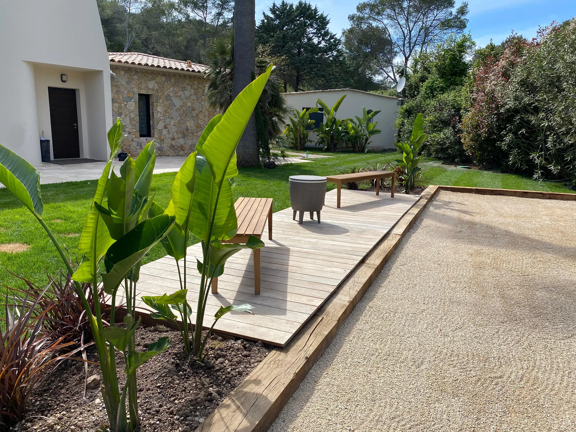 Terrasse en bois ipé avec banquette intégrée et plantes bananiers