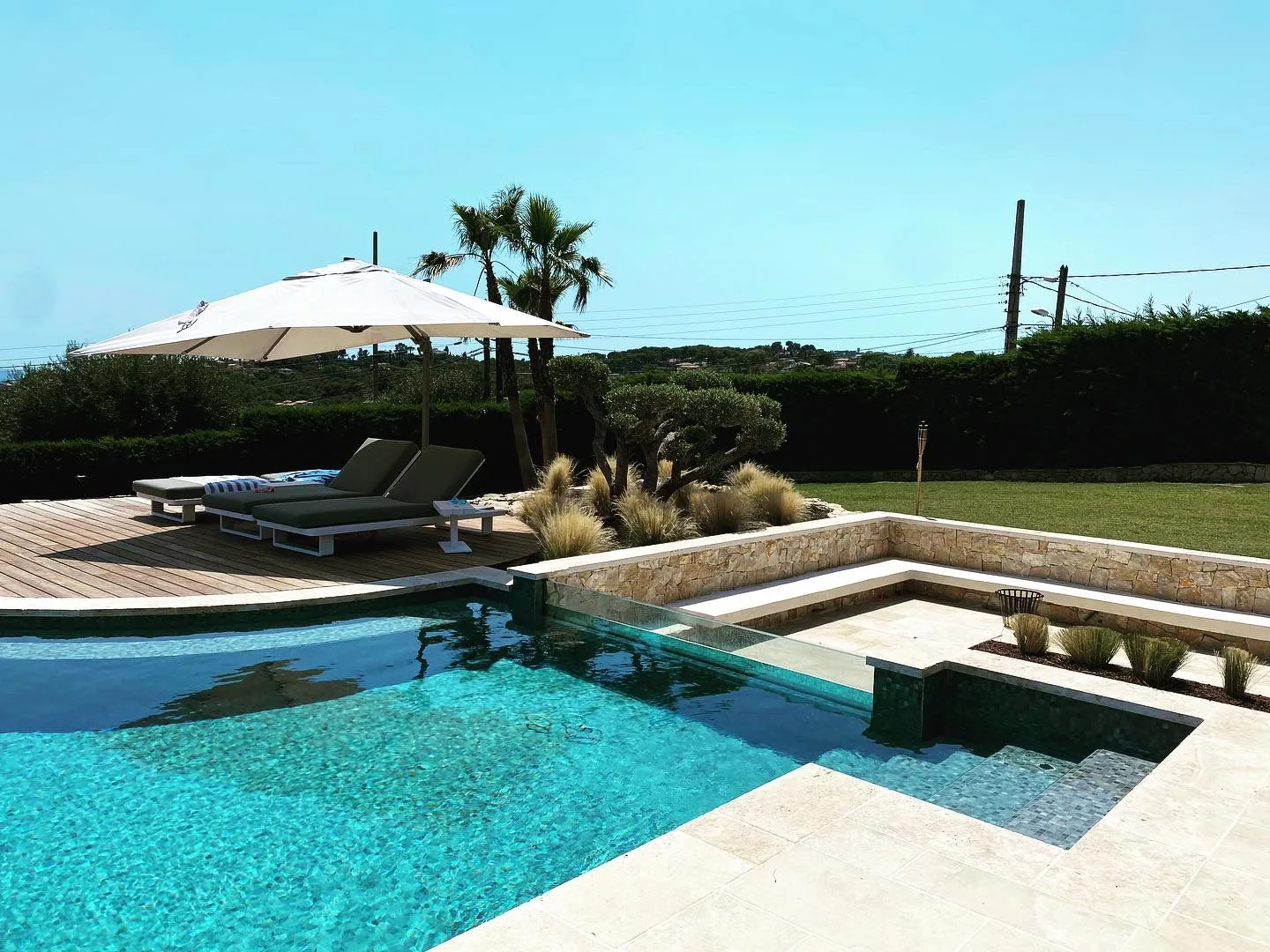 Jardin méditerranéen achevé avec piscine, terrasse bois et palmiers — réalisation Influence Paysage